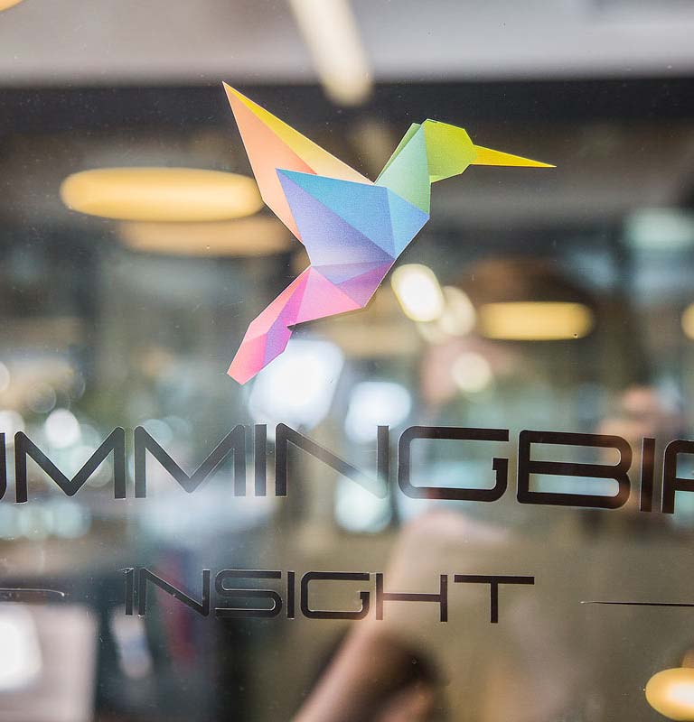 The Hummingbird Insight logo printed on a glass door